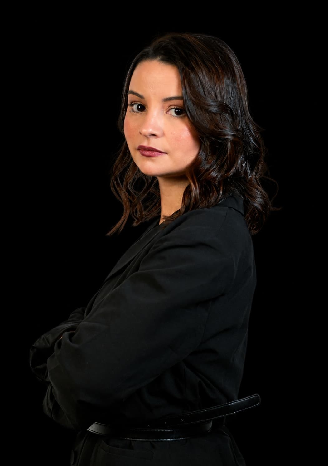 Bárbara Medeiros, advogada de Direito Digital, em retrato de estúdio com blazer preto, sobre fundo escuro